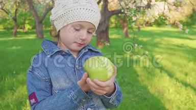 小女孩肖像吃绿苹果户外。 <strong>花圃</strong>背景上有苹果的女孩..